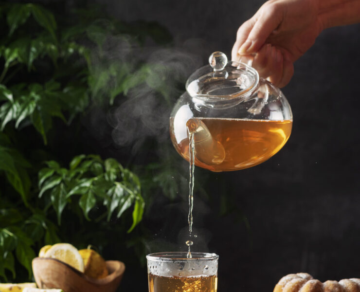 Woman Hand Pourung A Hot Black Tea