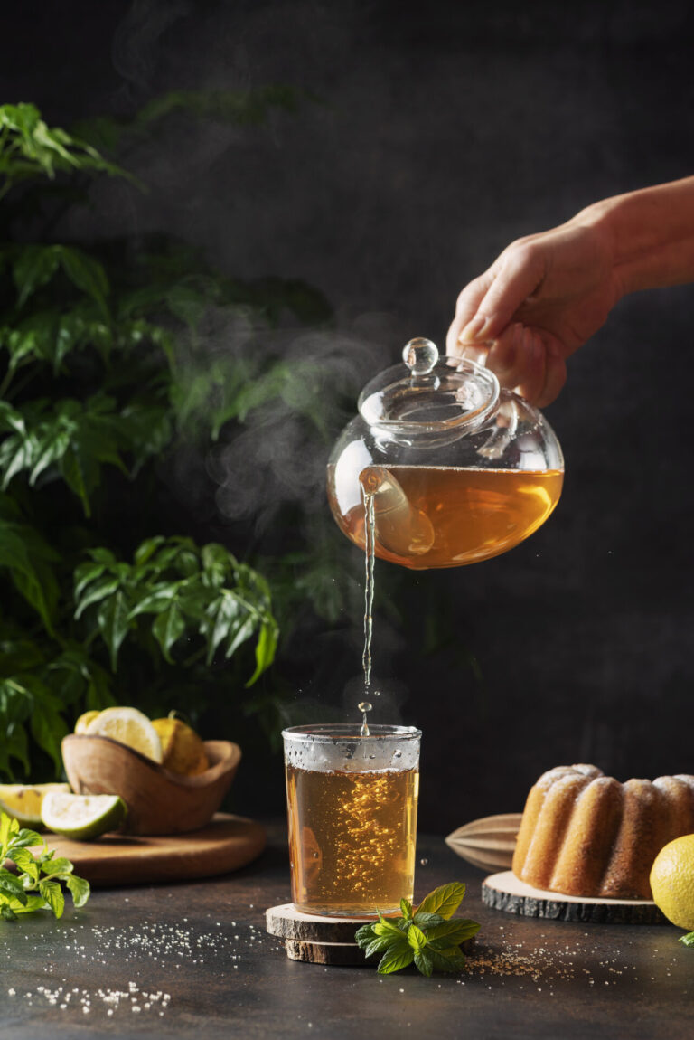 Woman Hand Pourung A Hot Black Tea